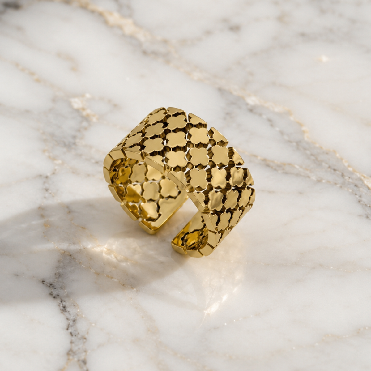A chunky gold ring on a marble surface