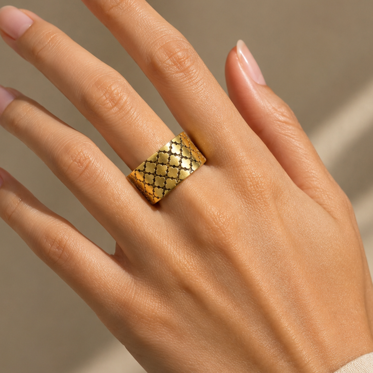 A woman wearing a gold cuff ring on her middle finger