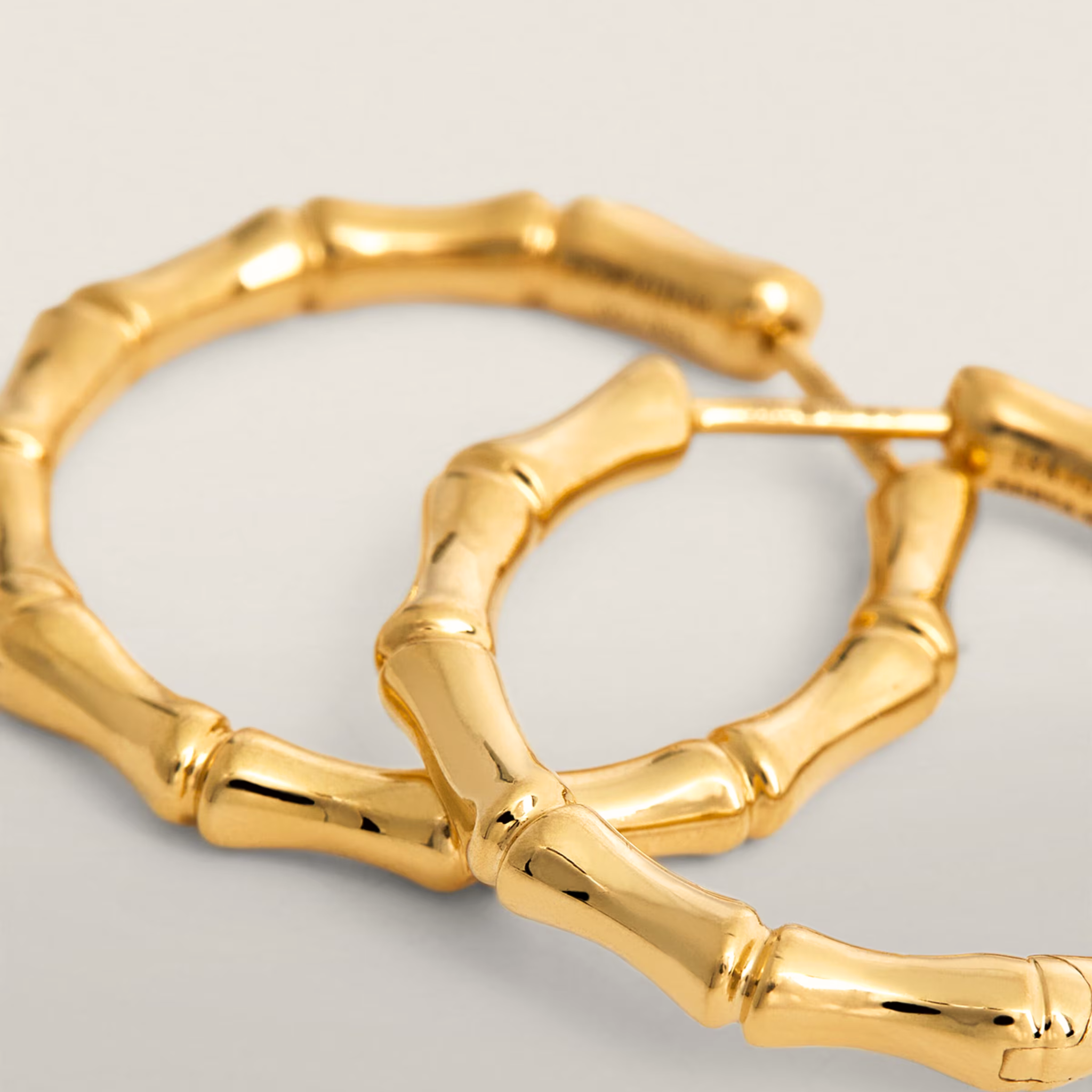 Gold hoop earrings on a light gray background