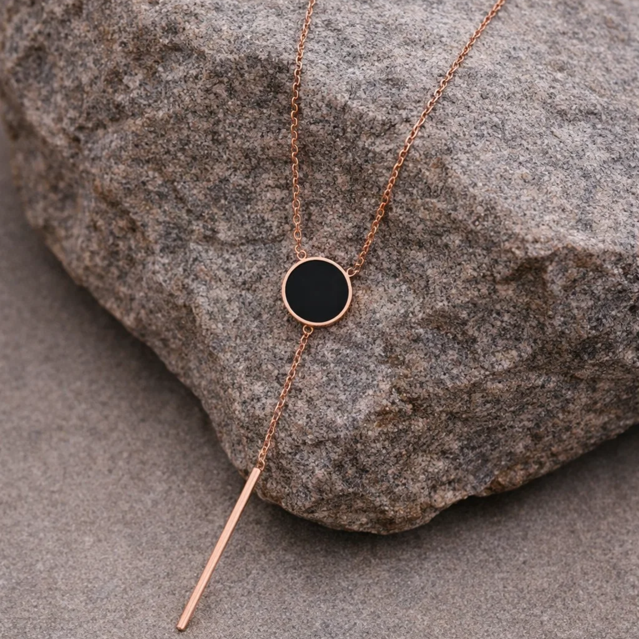 Gold necklace with a black pendant 