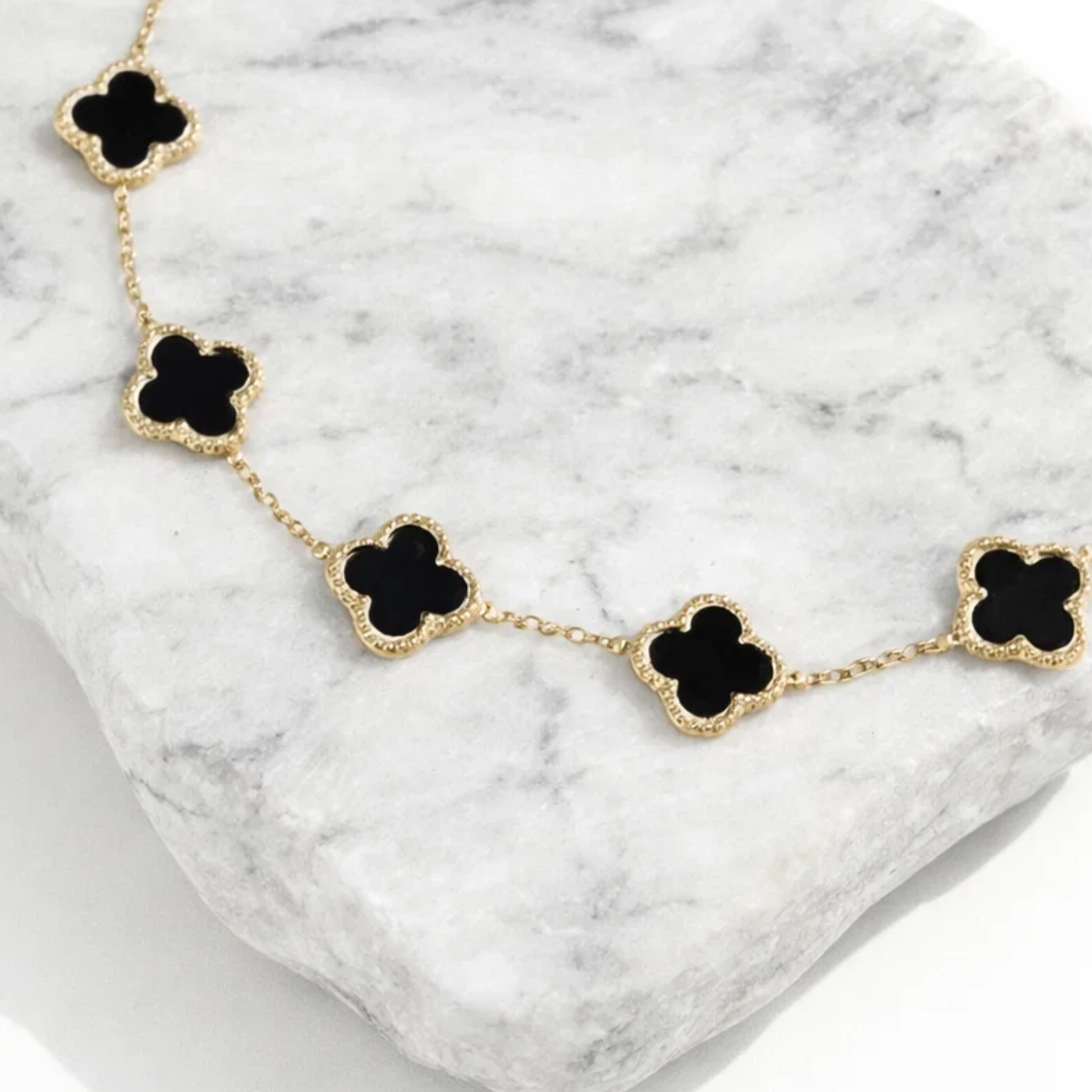 Clover bracelet on a piece of white marble