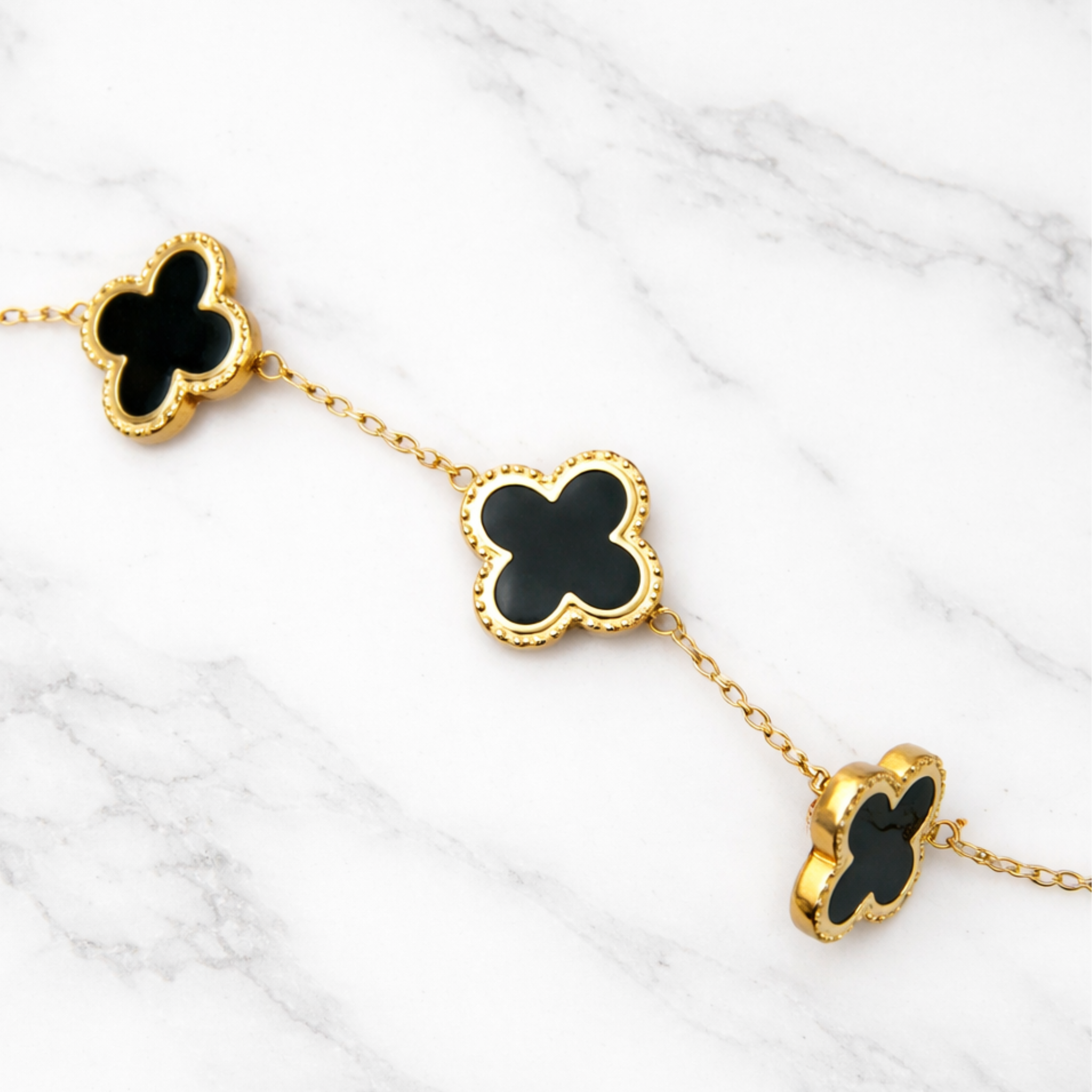 Black clover chain bracelet on a marble slab