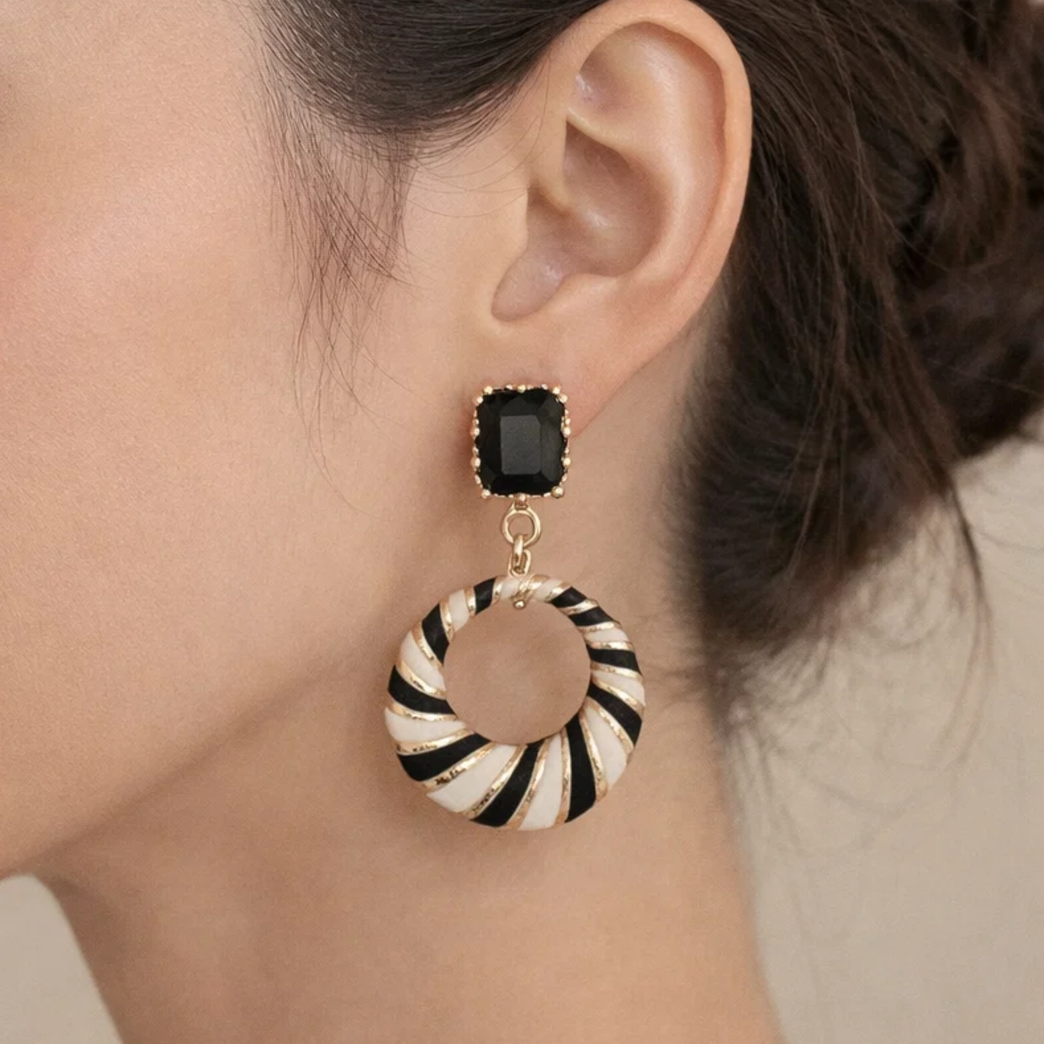 Close-up of an earring with a black gemstone and striped design 