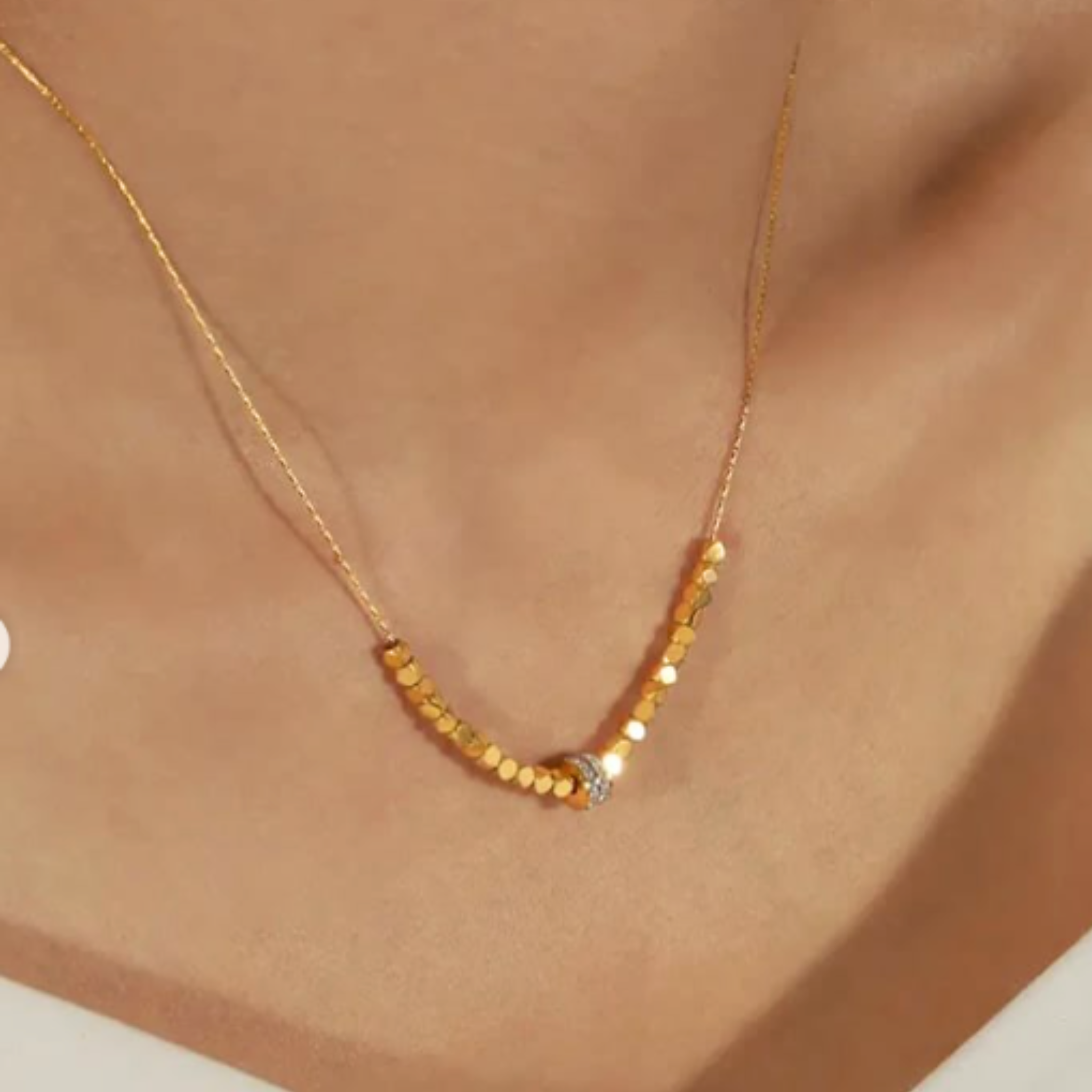 A woman wearing a gold beaded necklace