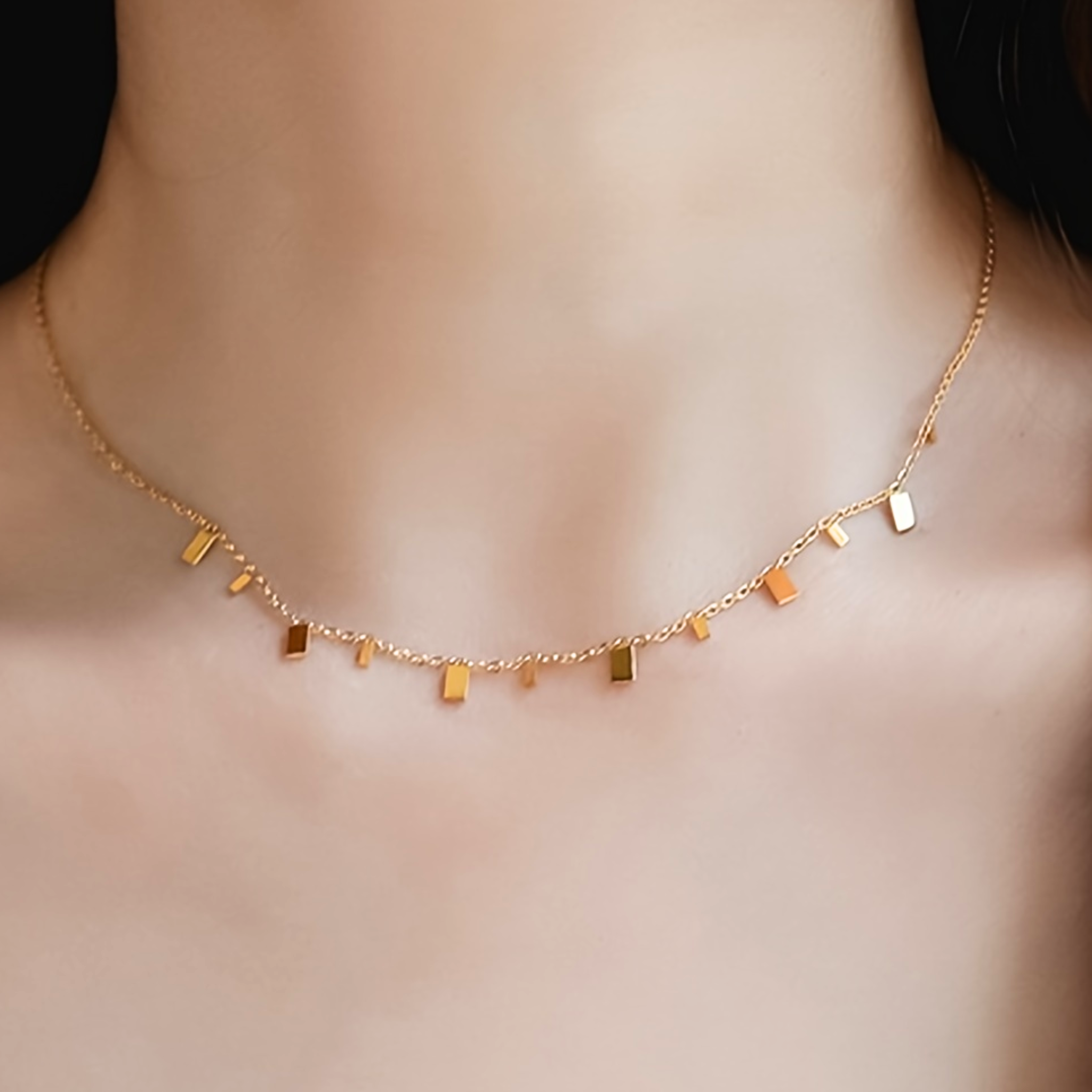 Gold necklace with small rectangular pendants 