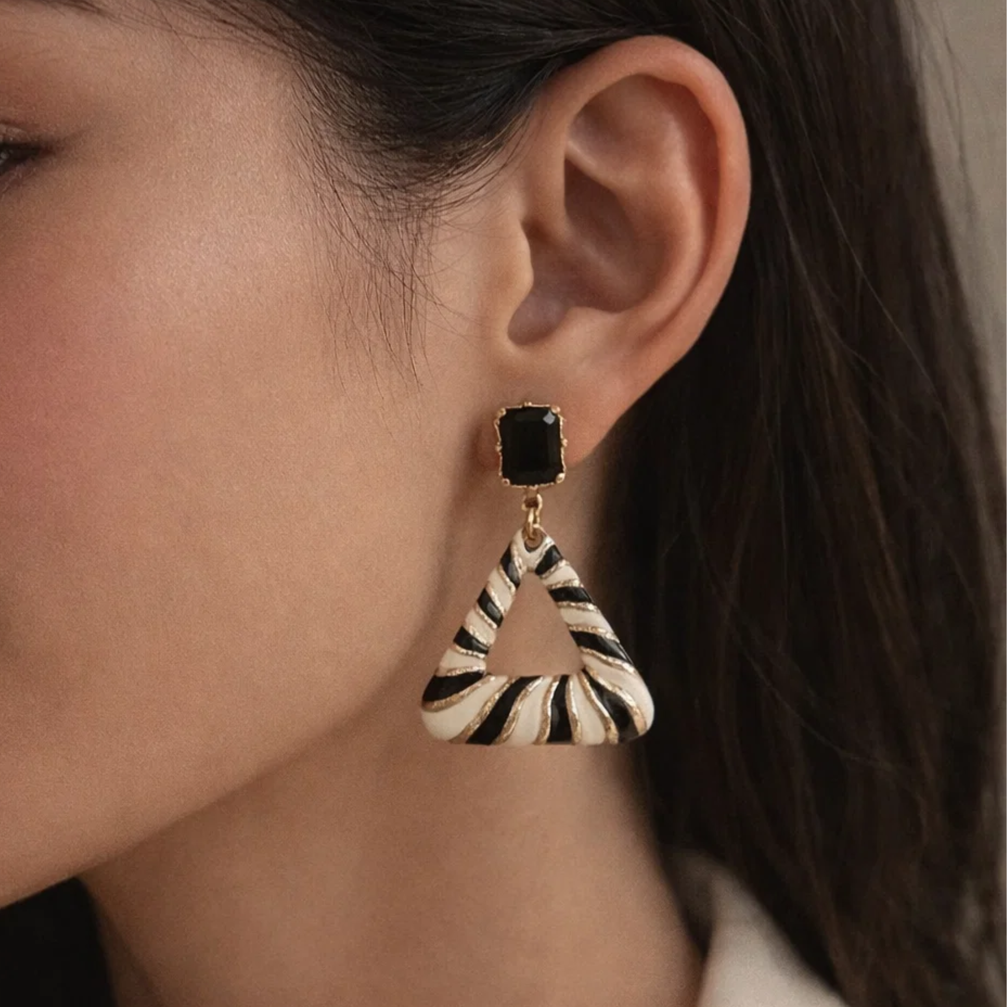 A woman wearing a triangle stripe earrings