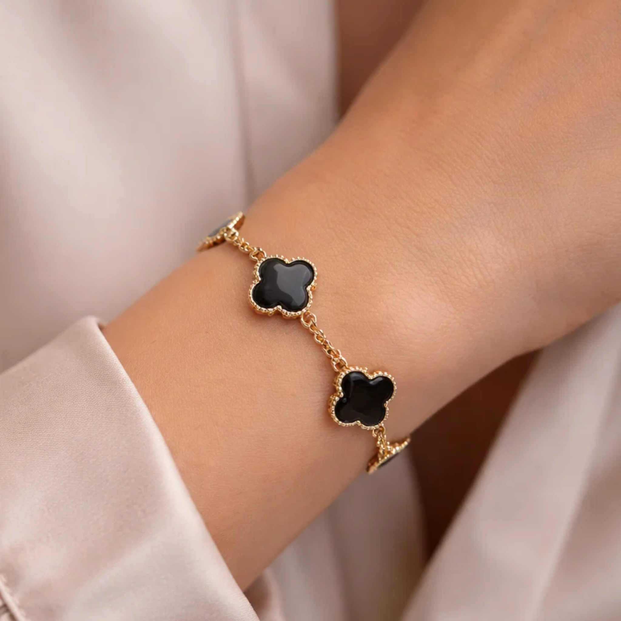 A woman wearing a black clover bracelet