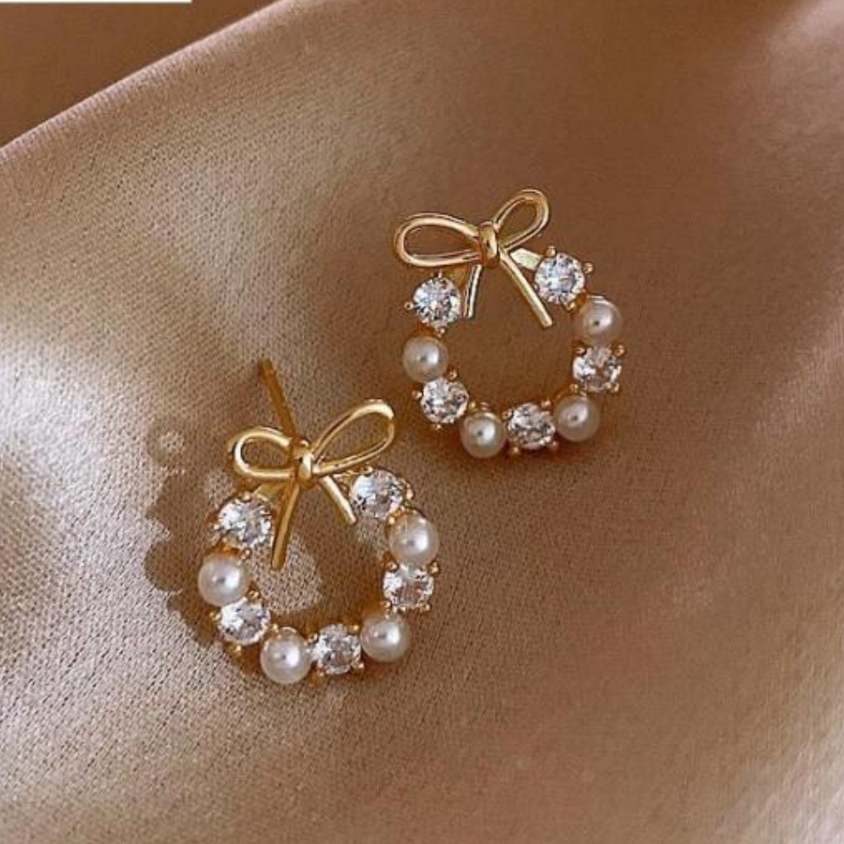 A pair of hoop earrings on a silk cloth