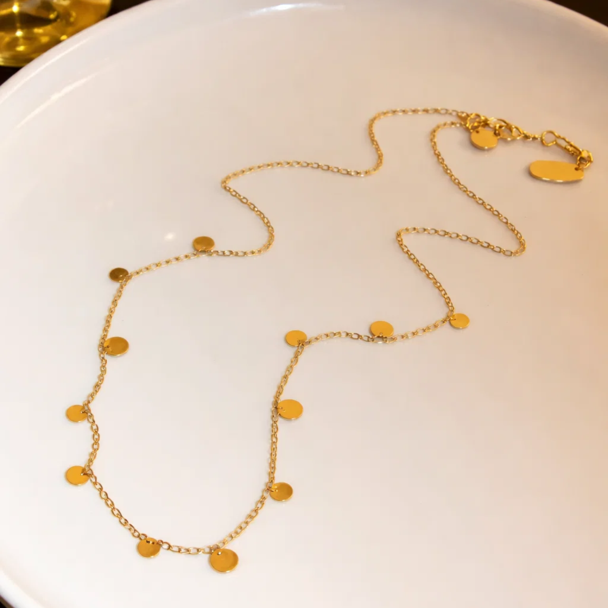 Gold necklace on a white plate