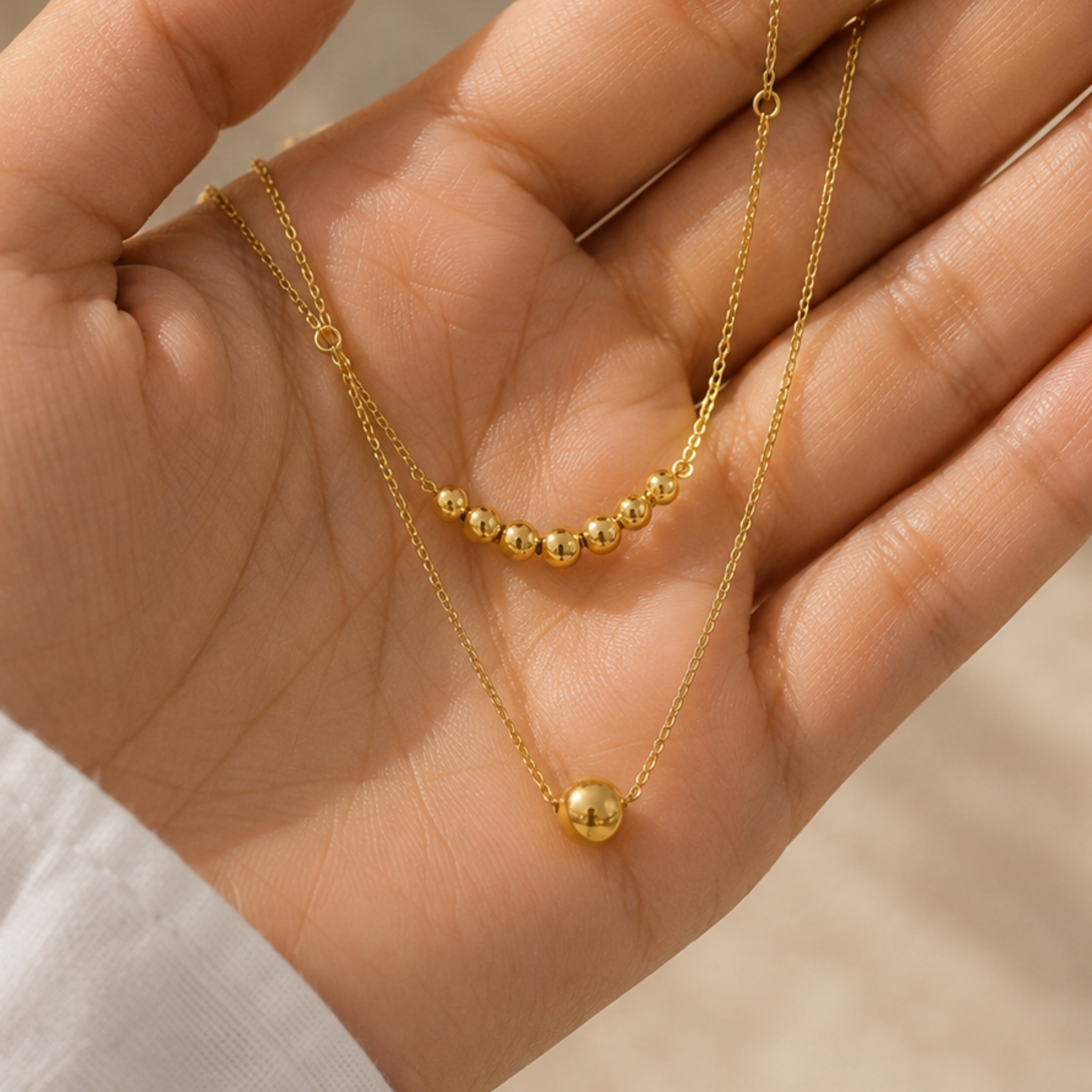 A woman holding a double-layered necklace