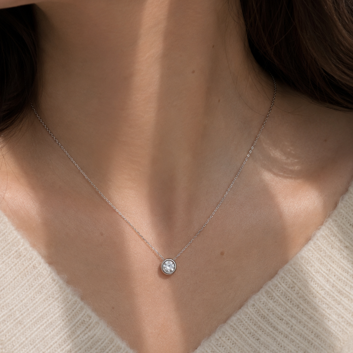 A woman wearing a minimalistic silver sphere pendant necklace