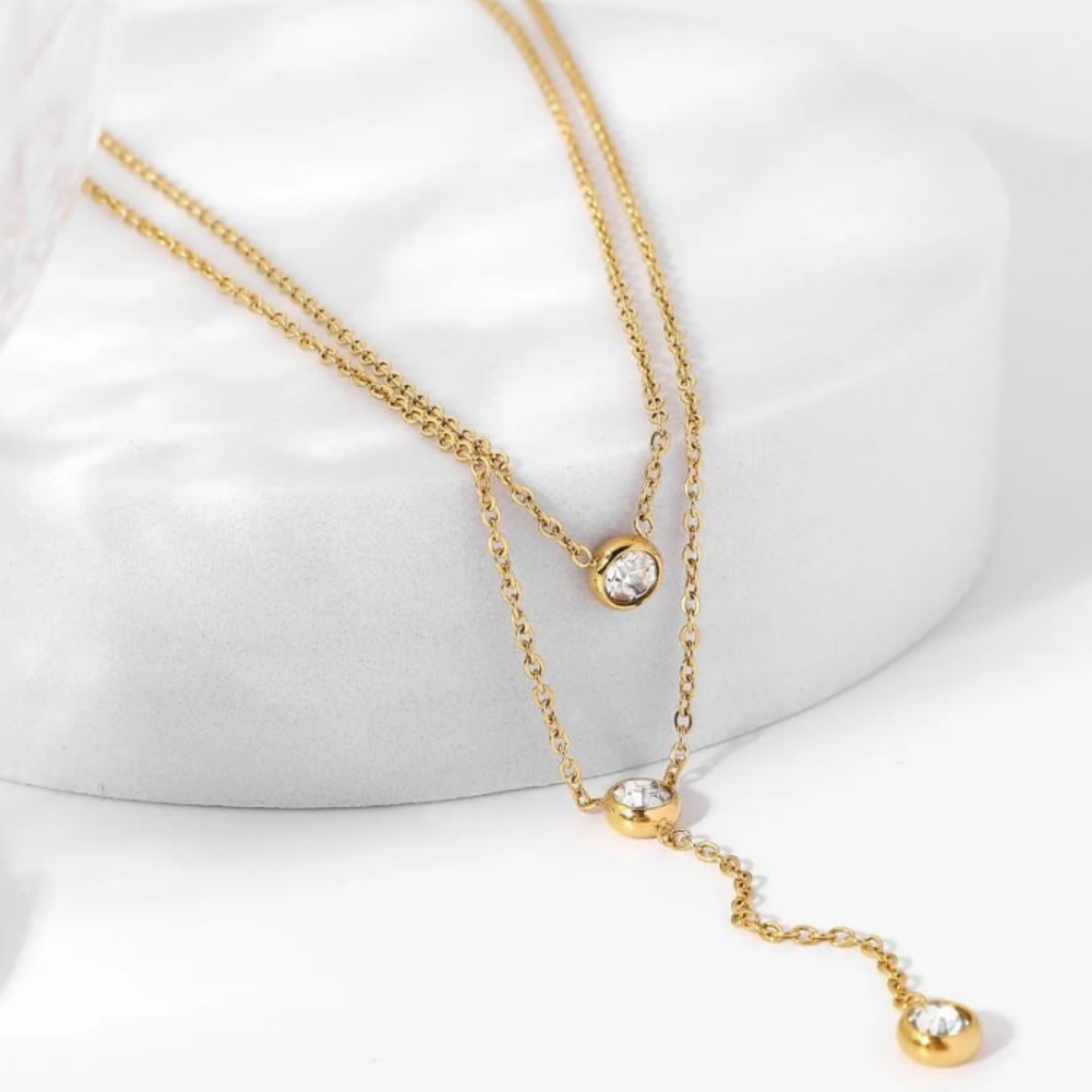 Gold necklace with crystal pendants on a white background
