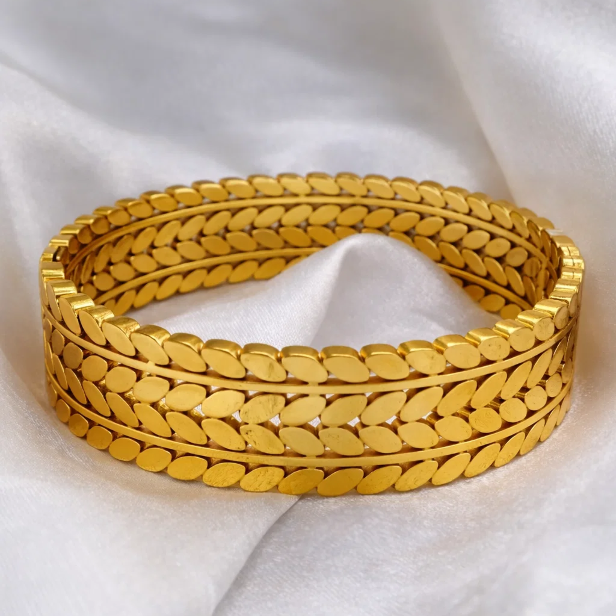Gold bracelet on a white fabric background