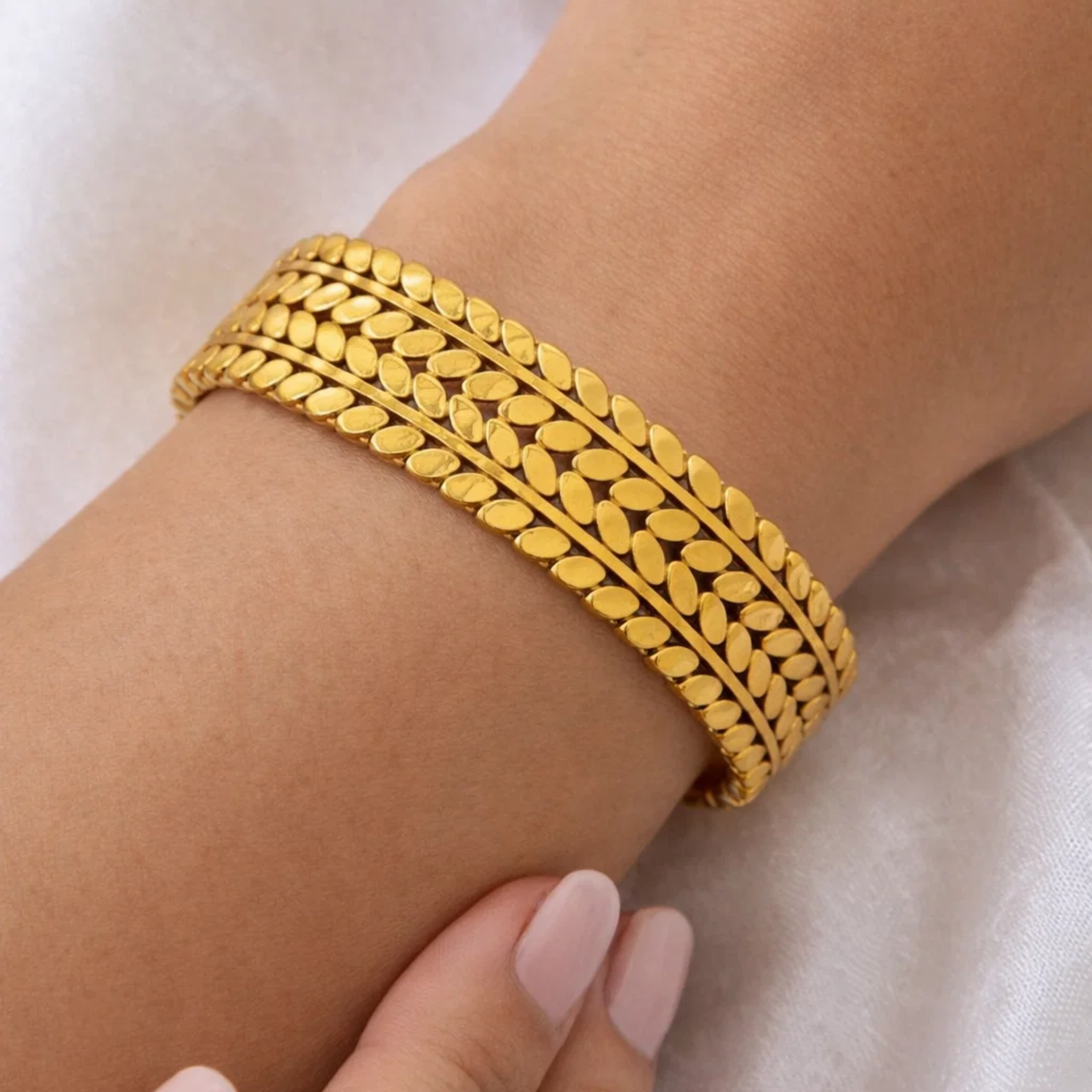 A woman wearing a gold cuff bangle