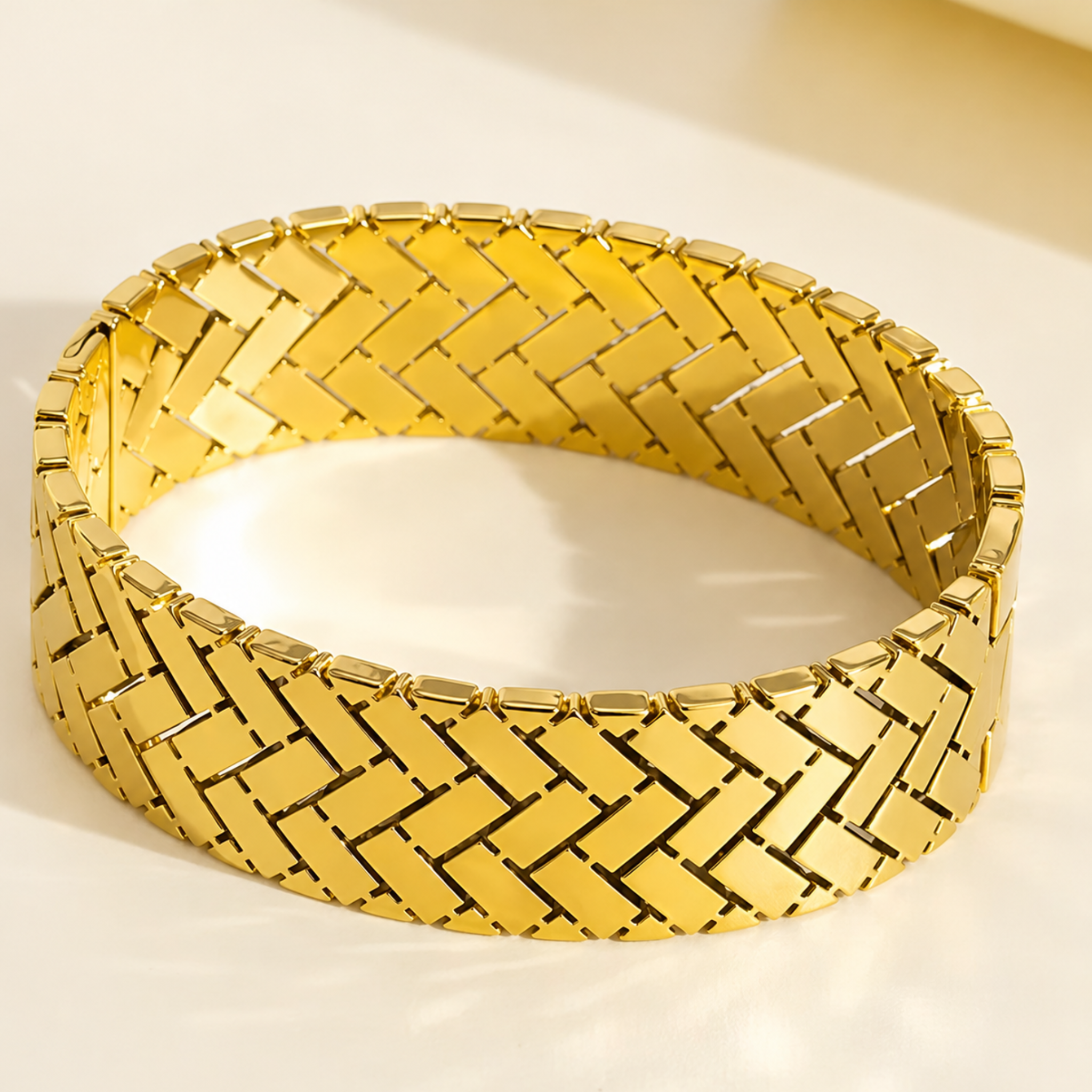 Gold bracelet with woven pattern on a light background