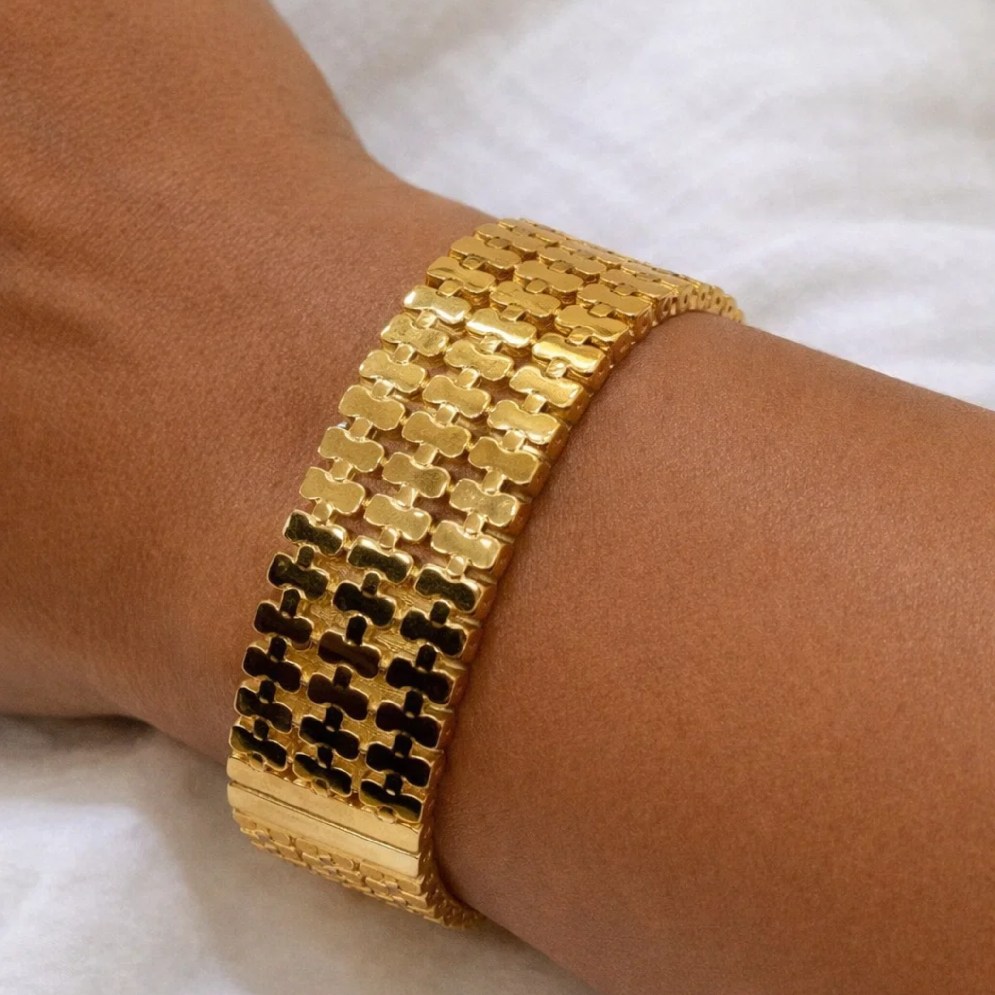 A woman wearing a gold cuff bangle