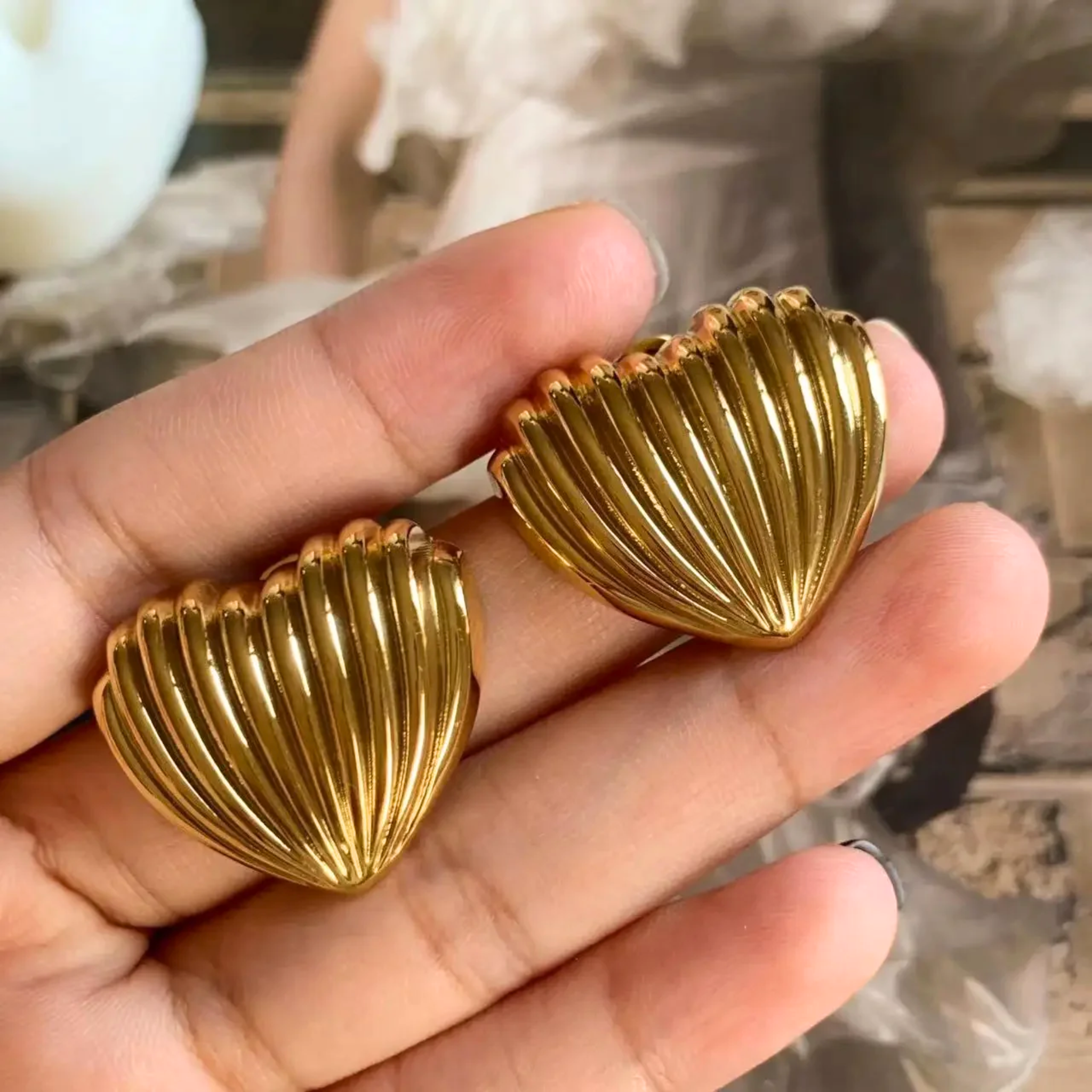 A woman holding shell earrings