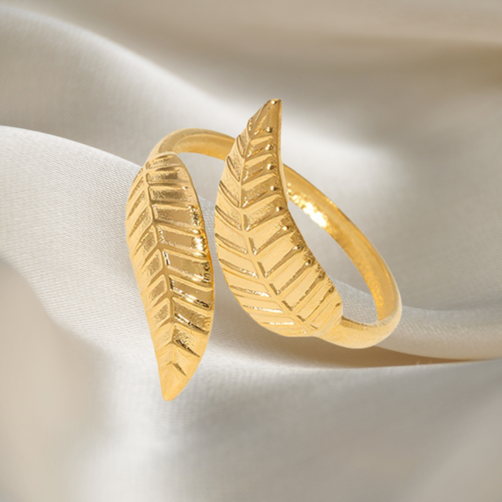 A stainless steel leaf ring on a silk background