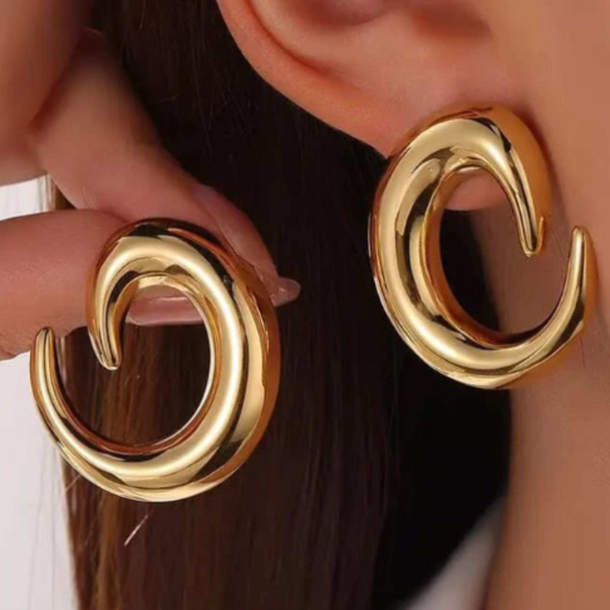 A woman wearing gold hoop earrings