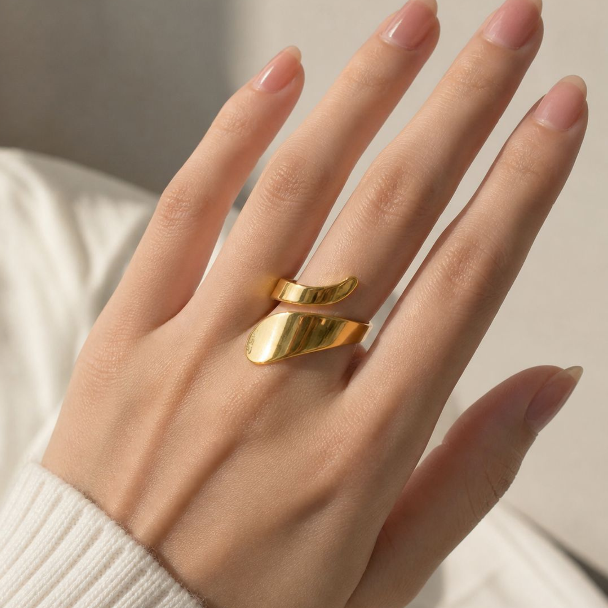 A woman wearing a gold sculptural ring