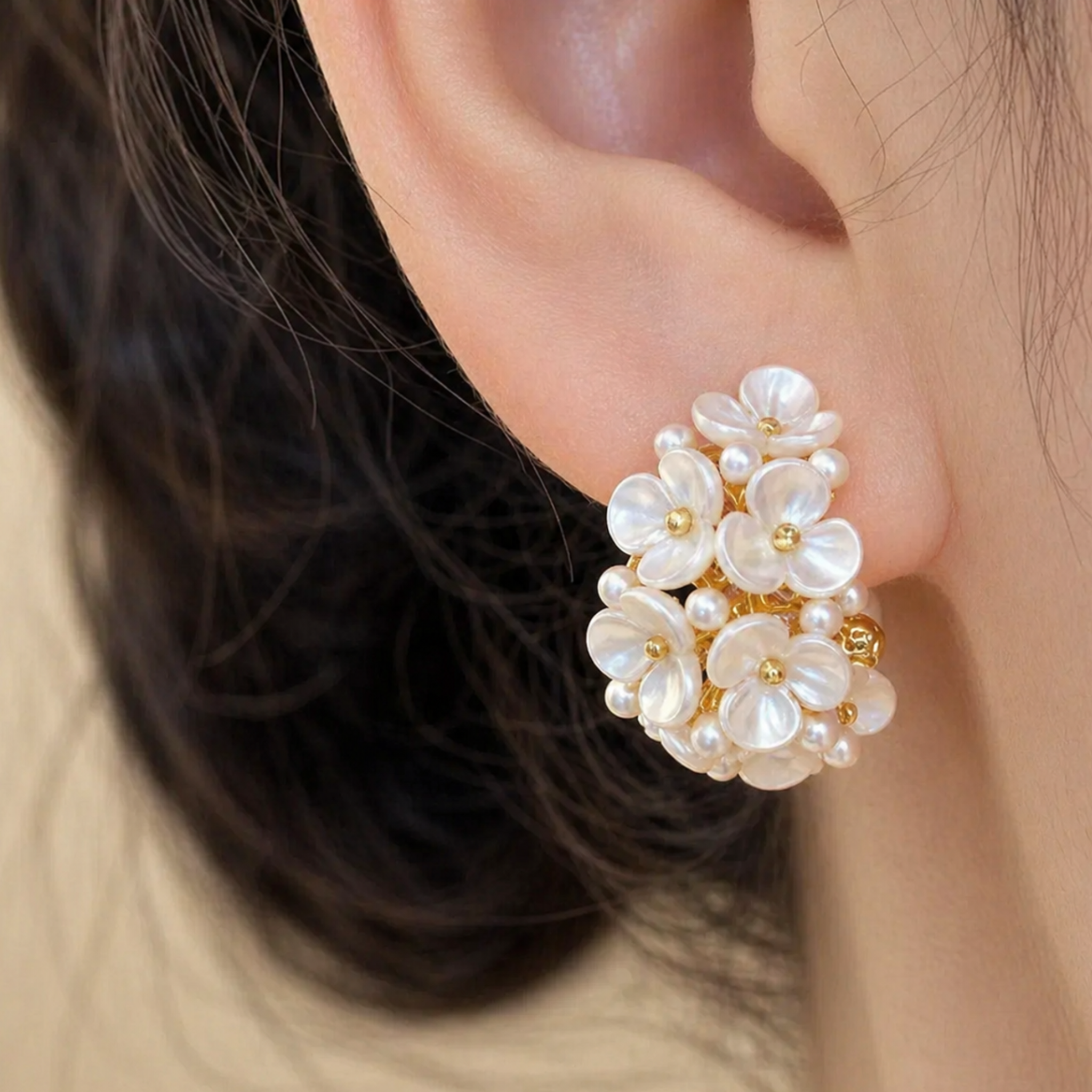 A woman wearing gold floral earring
