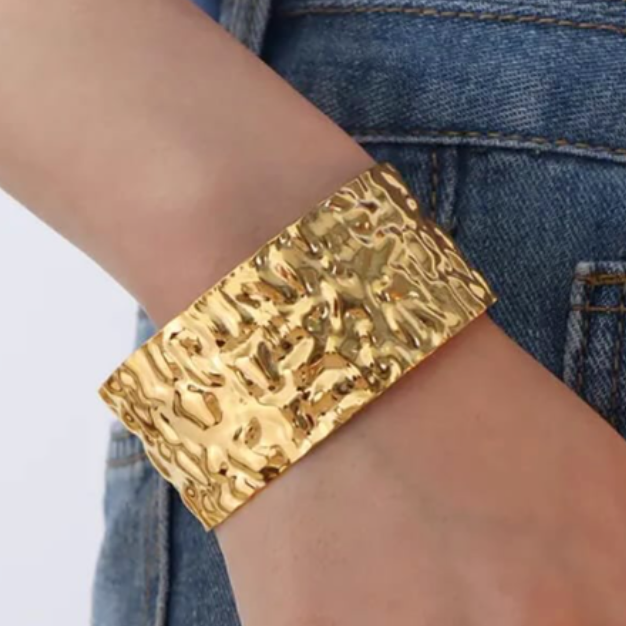 A woman wearing a gold cuff bangle
