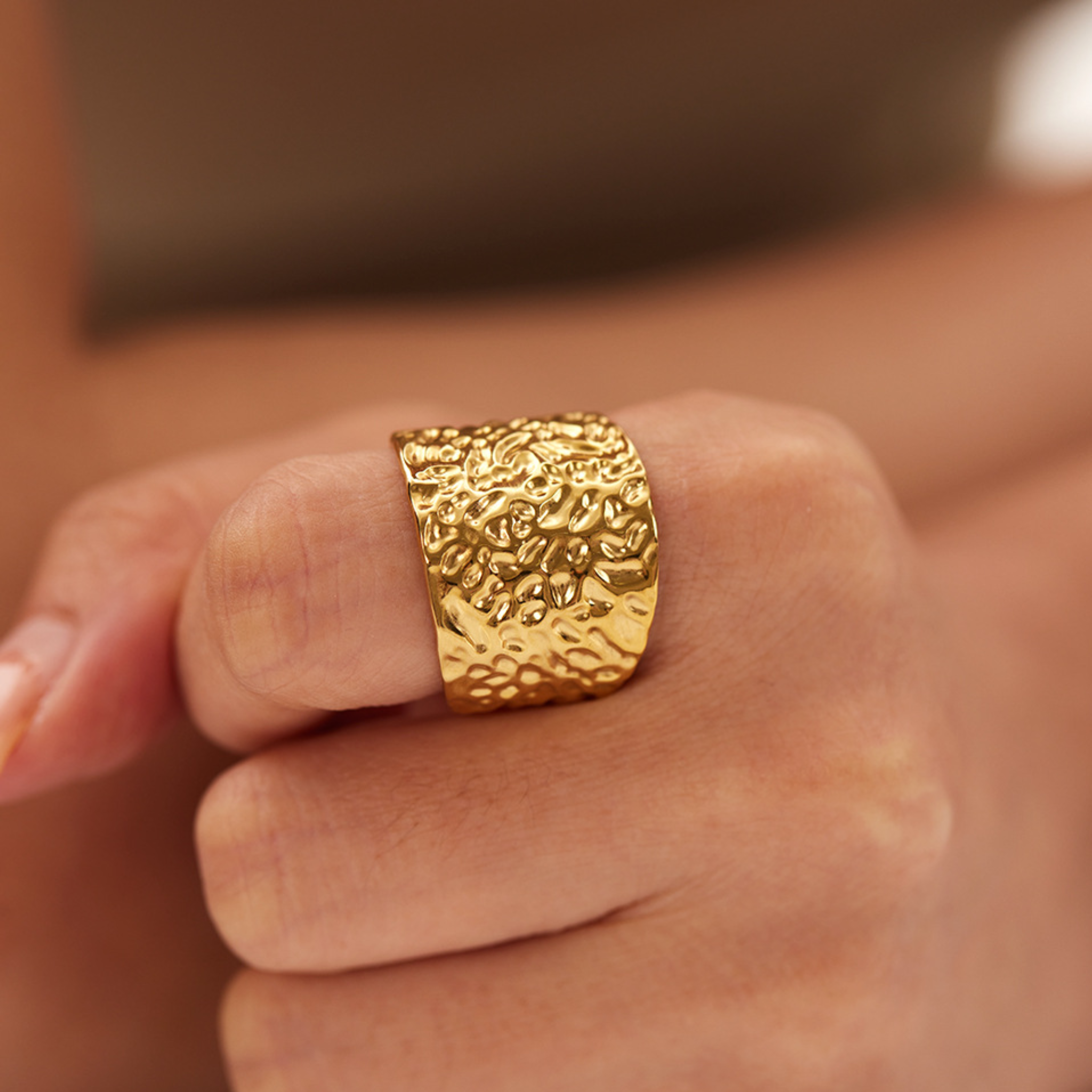 A woman wearing a hammer textured gold ring