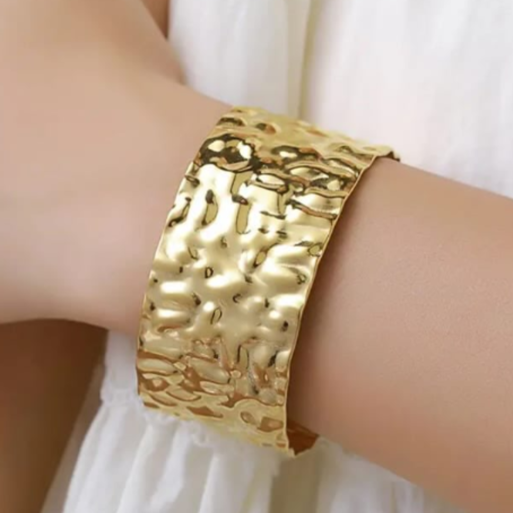Gold textured cuff on a wrist 