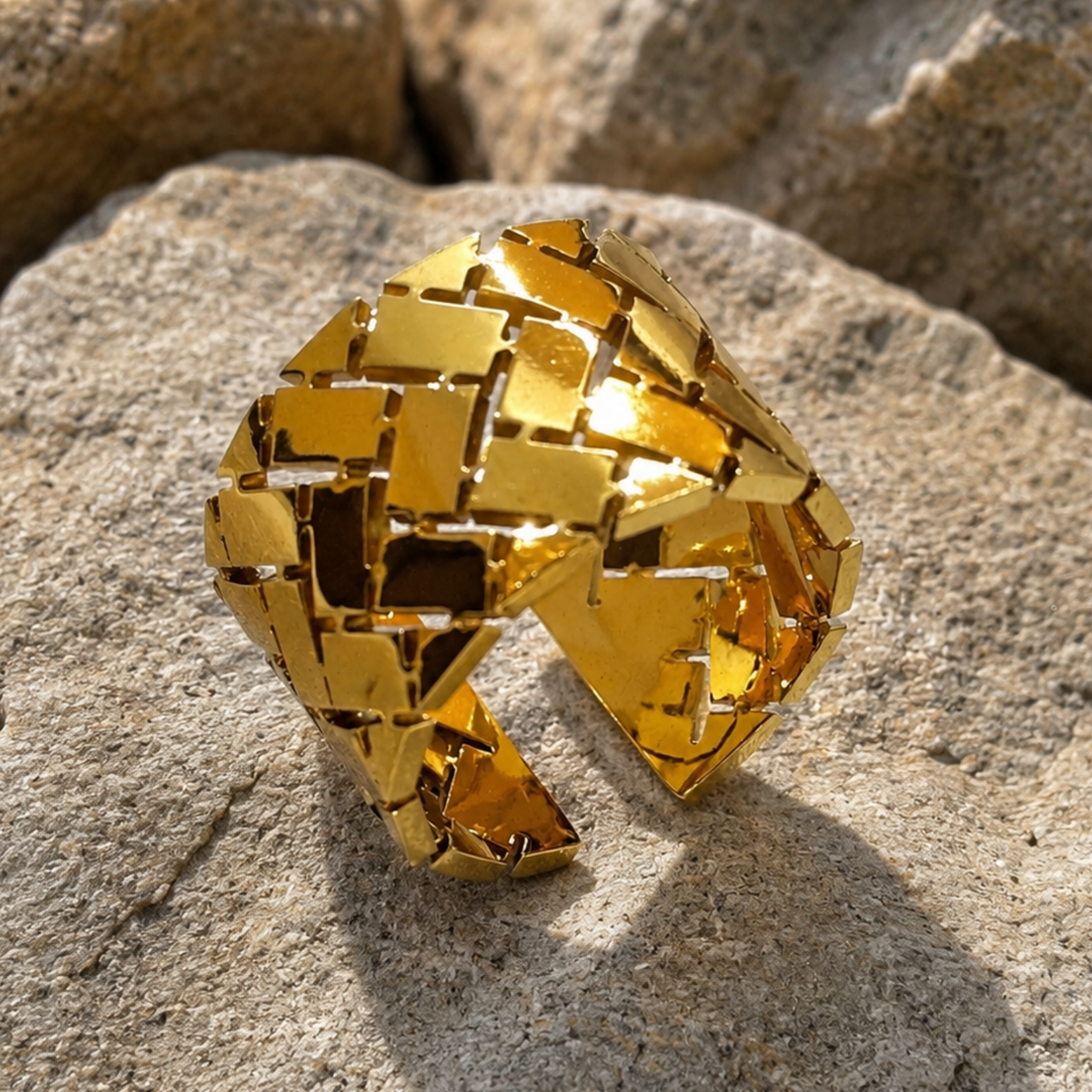 A chunky gold cuff ring with a geometric, woven-look design 