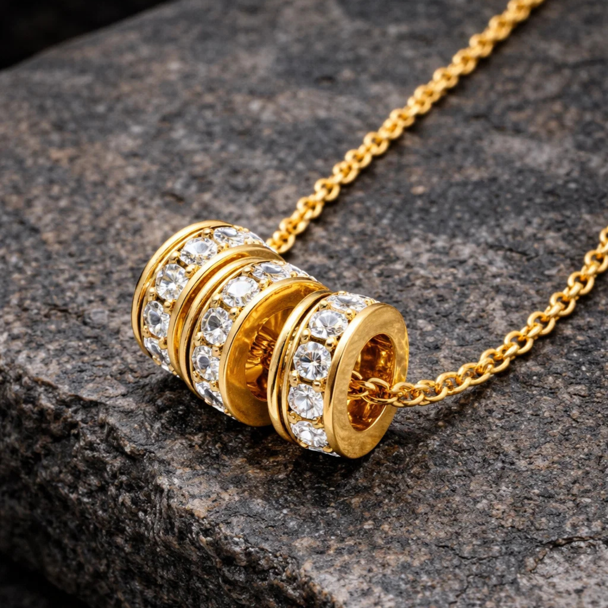 Gold necklace with a beaded pendant on a dark stone surface