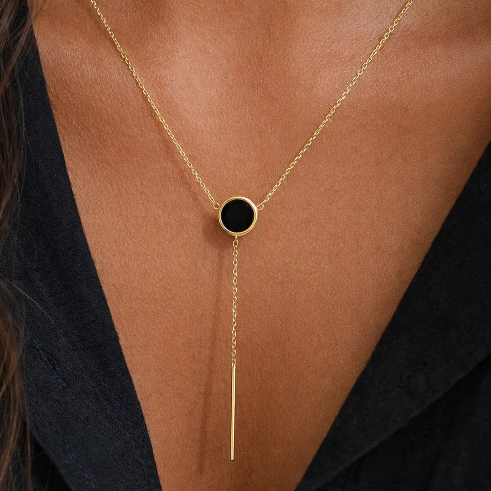 A woman wearing a black pendant necklace