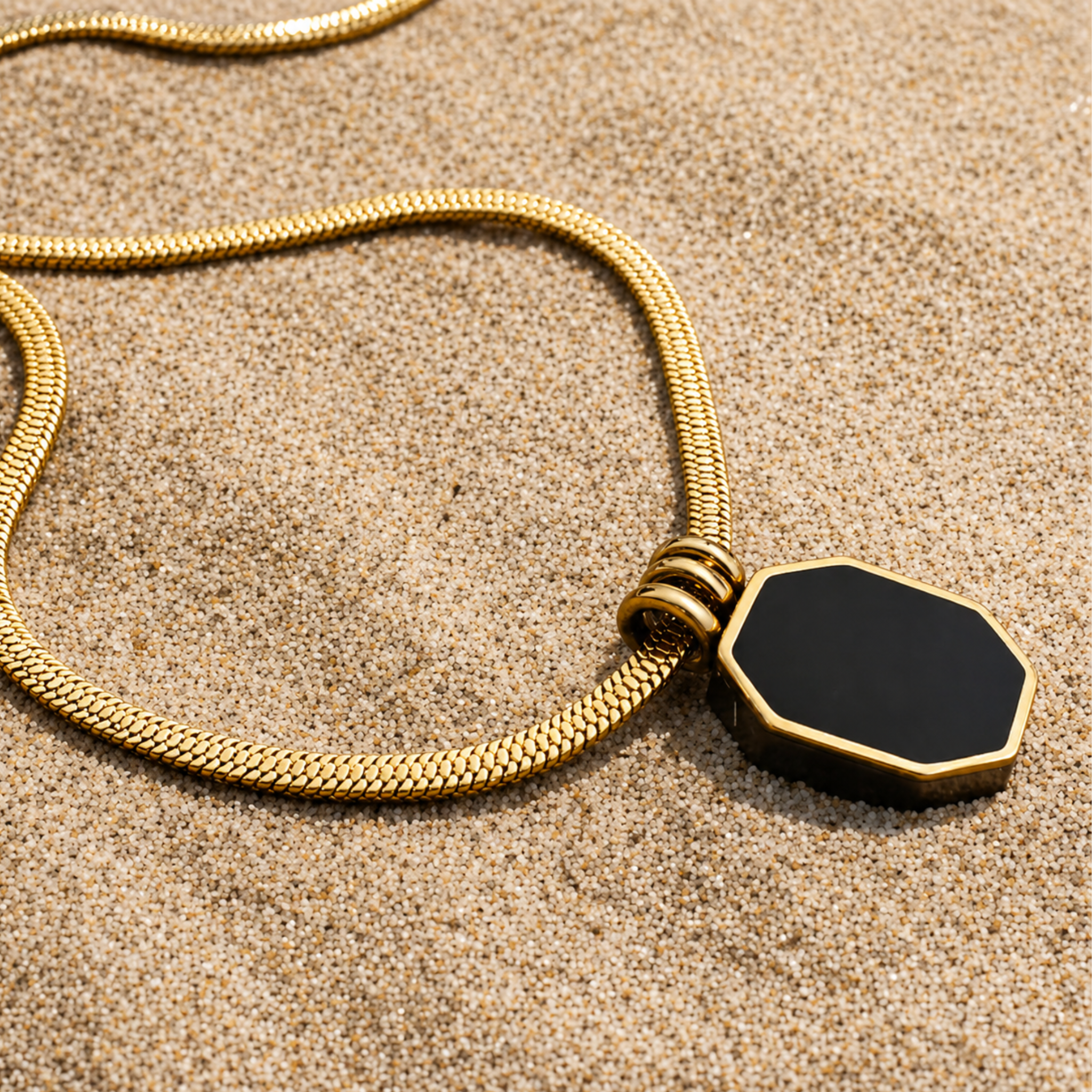 Black pendant necklace on a sand
