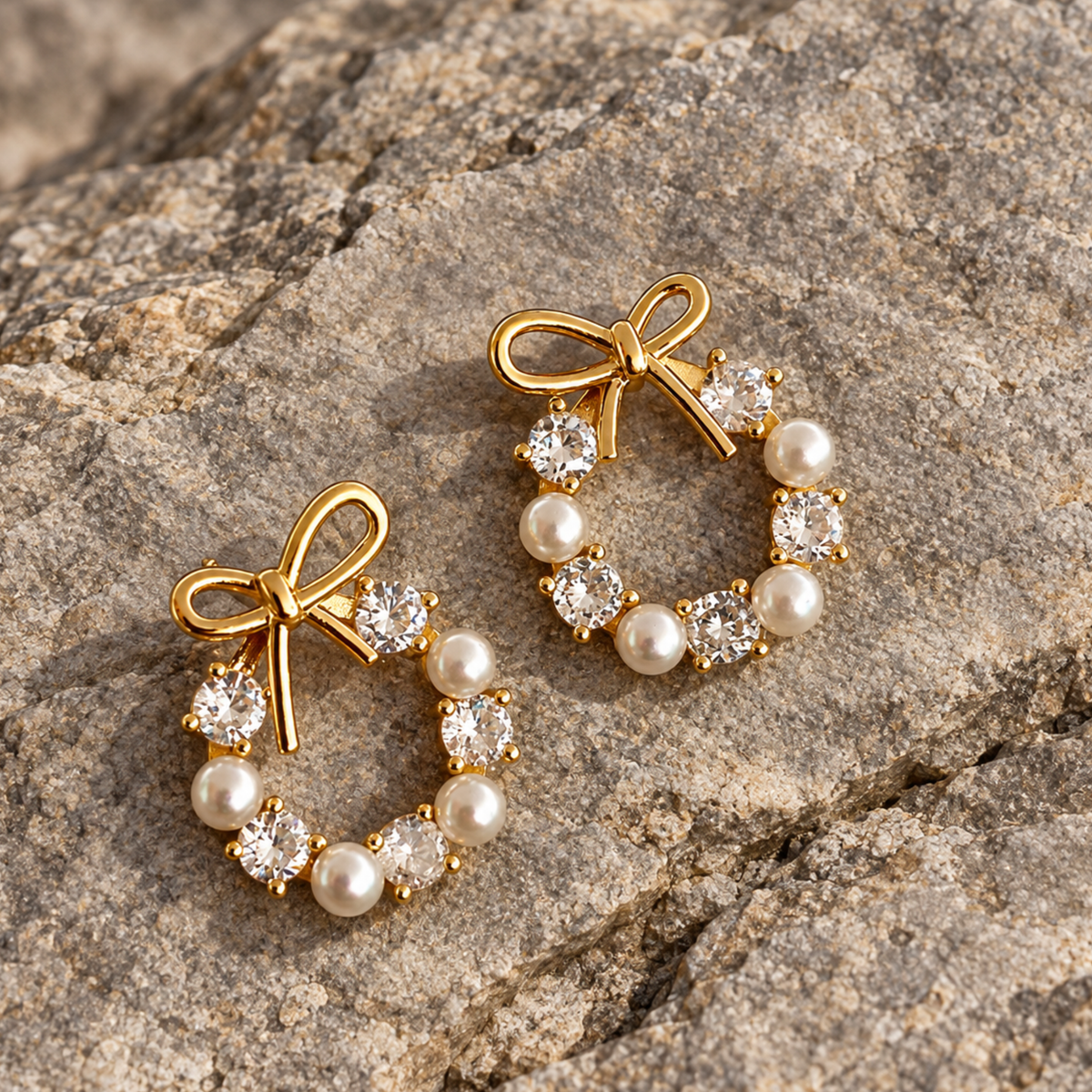 A pair of minimalistic pearl and bow earrings