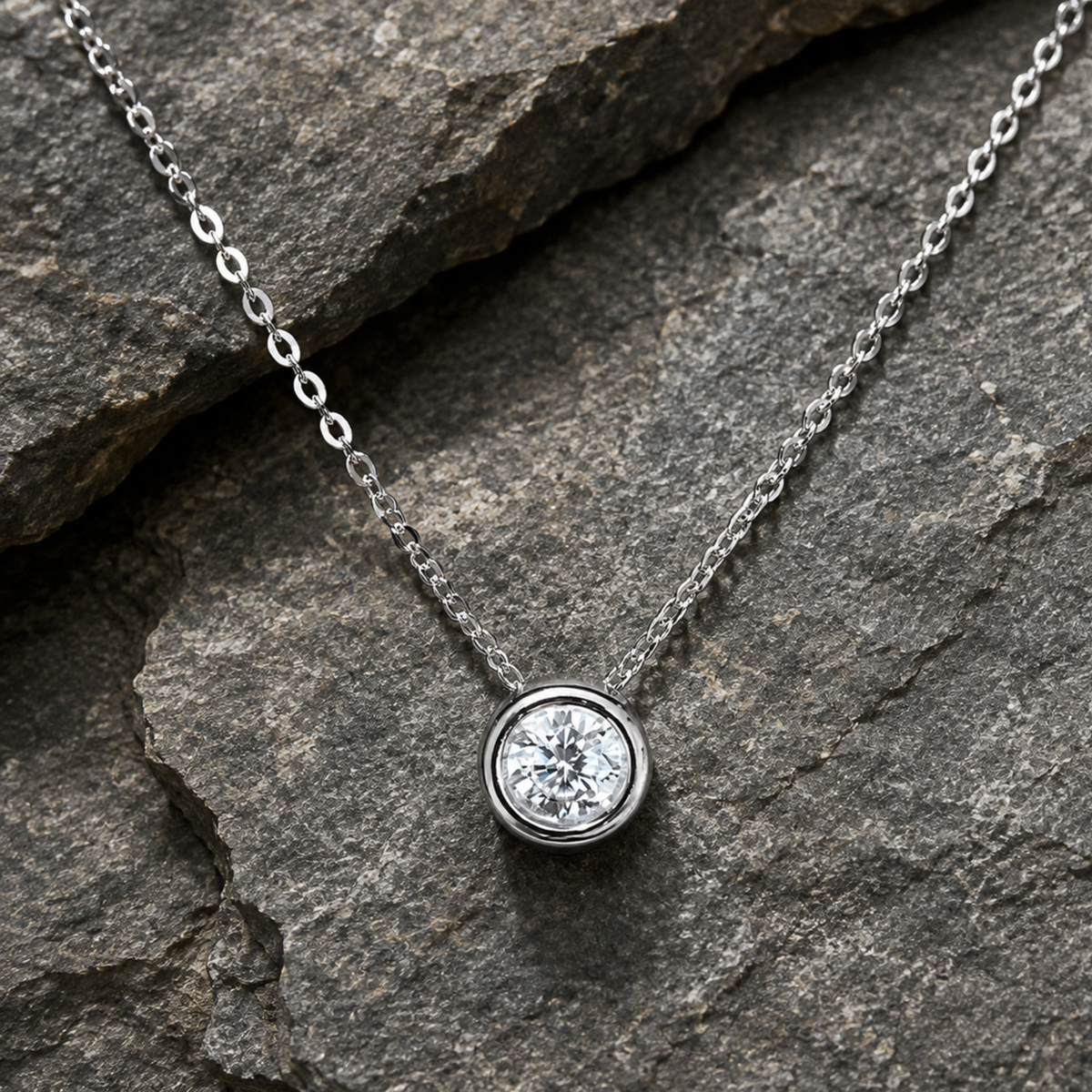 A silver chain necklace with a round bezel-set 