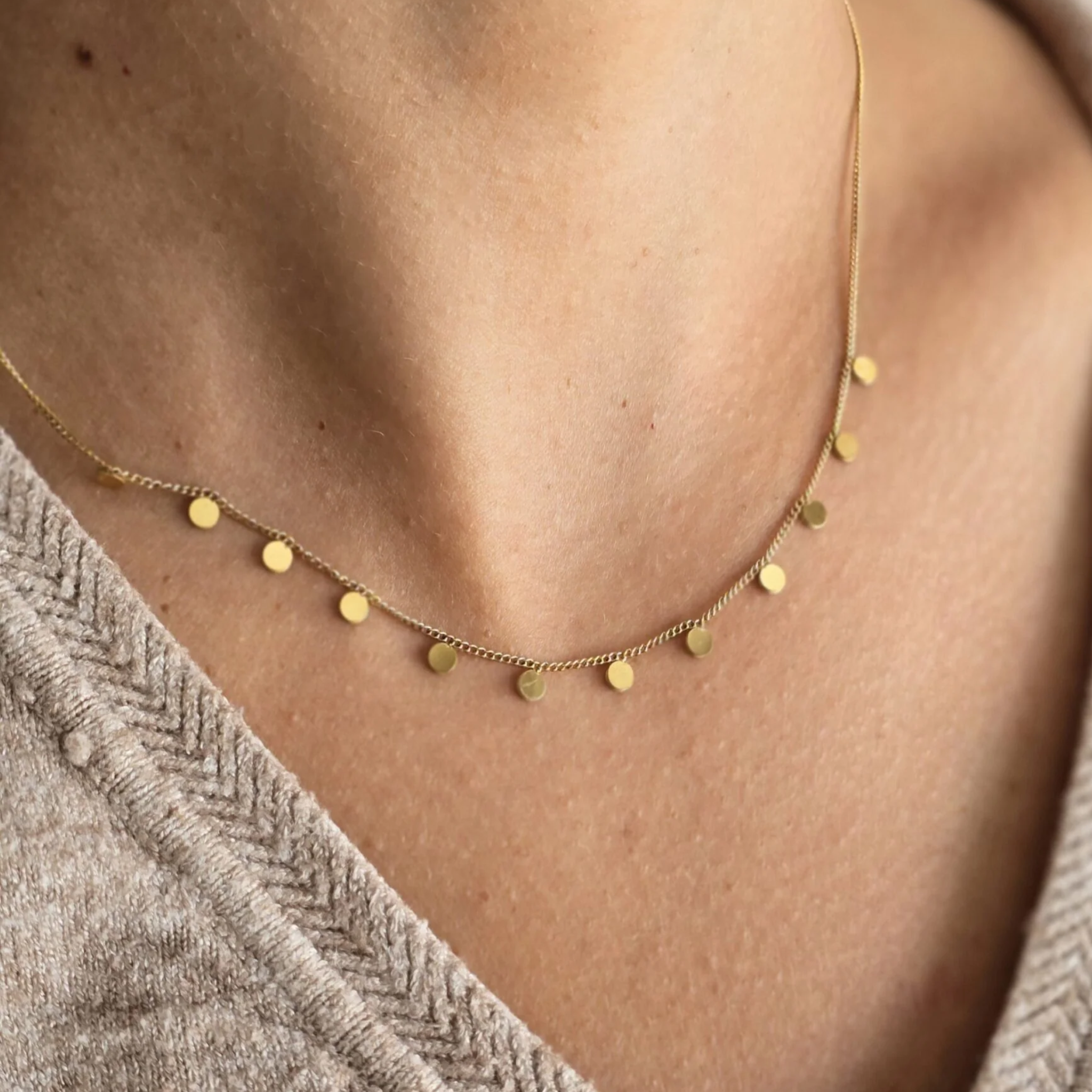 A woman wearing a circular charms necklace
