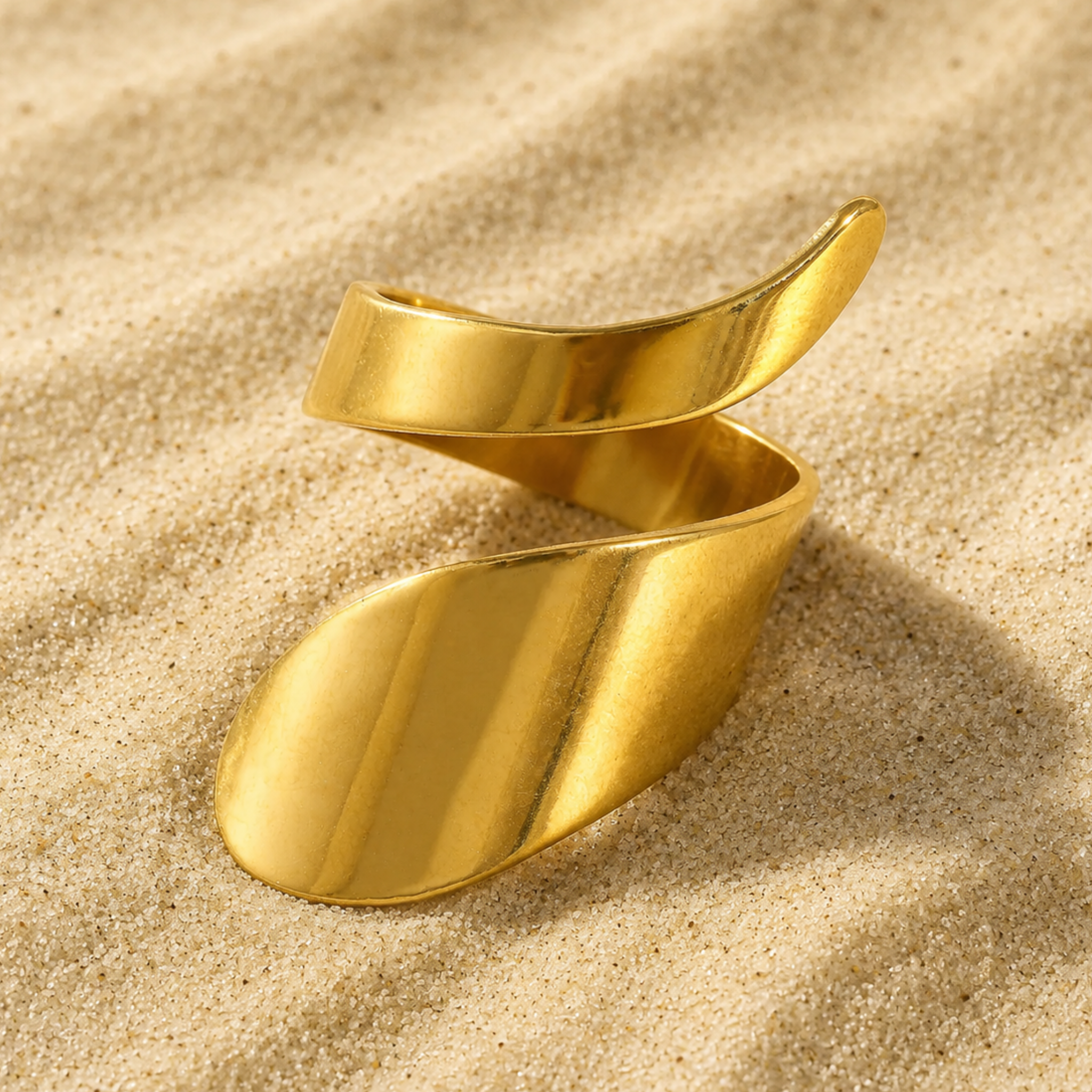 Gold spiral ring on a sand