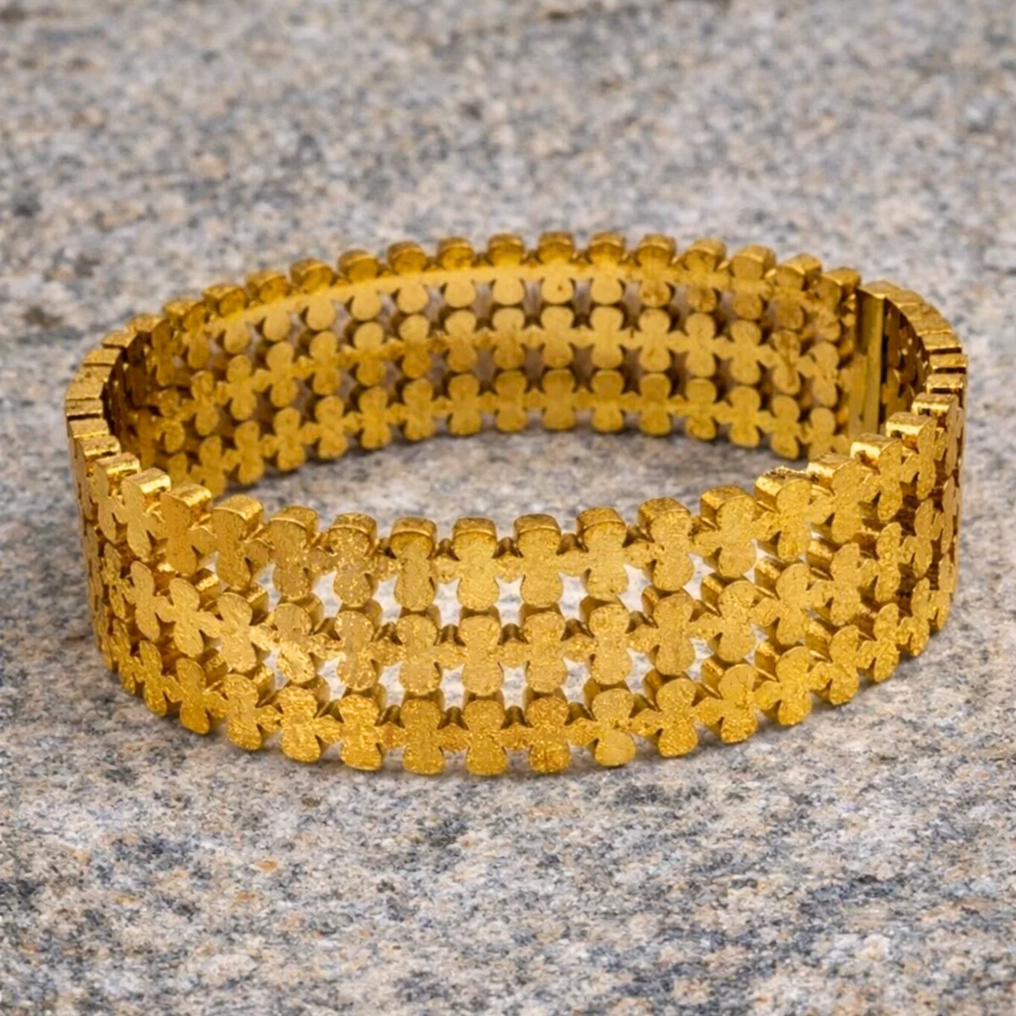 Gold bangle on a textured stone surface