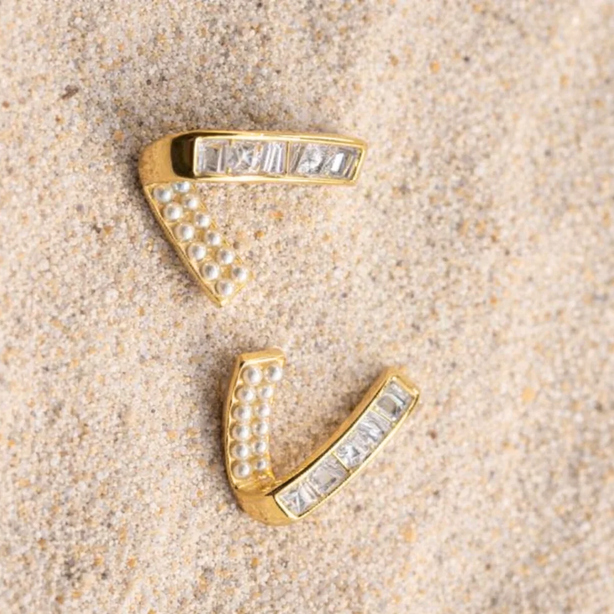Casual V shaped earrings on a beach sand