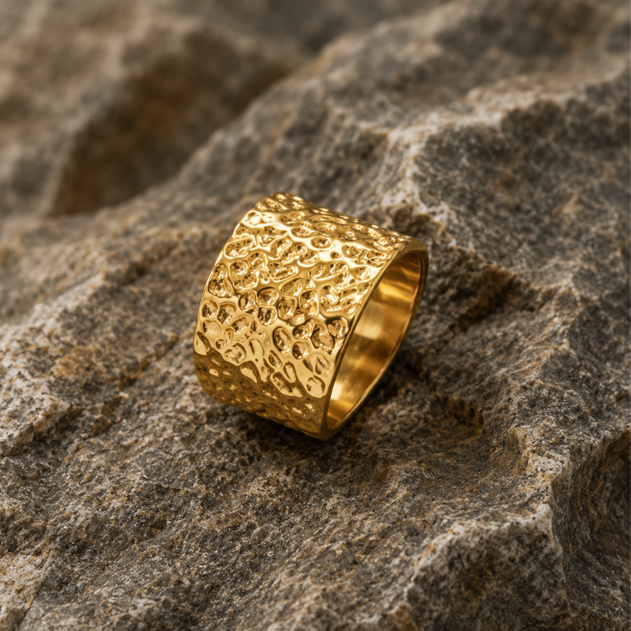 A hammer textured ring on a rock background