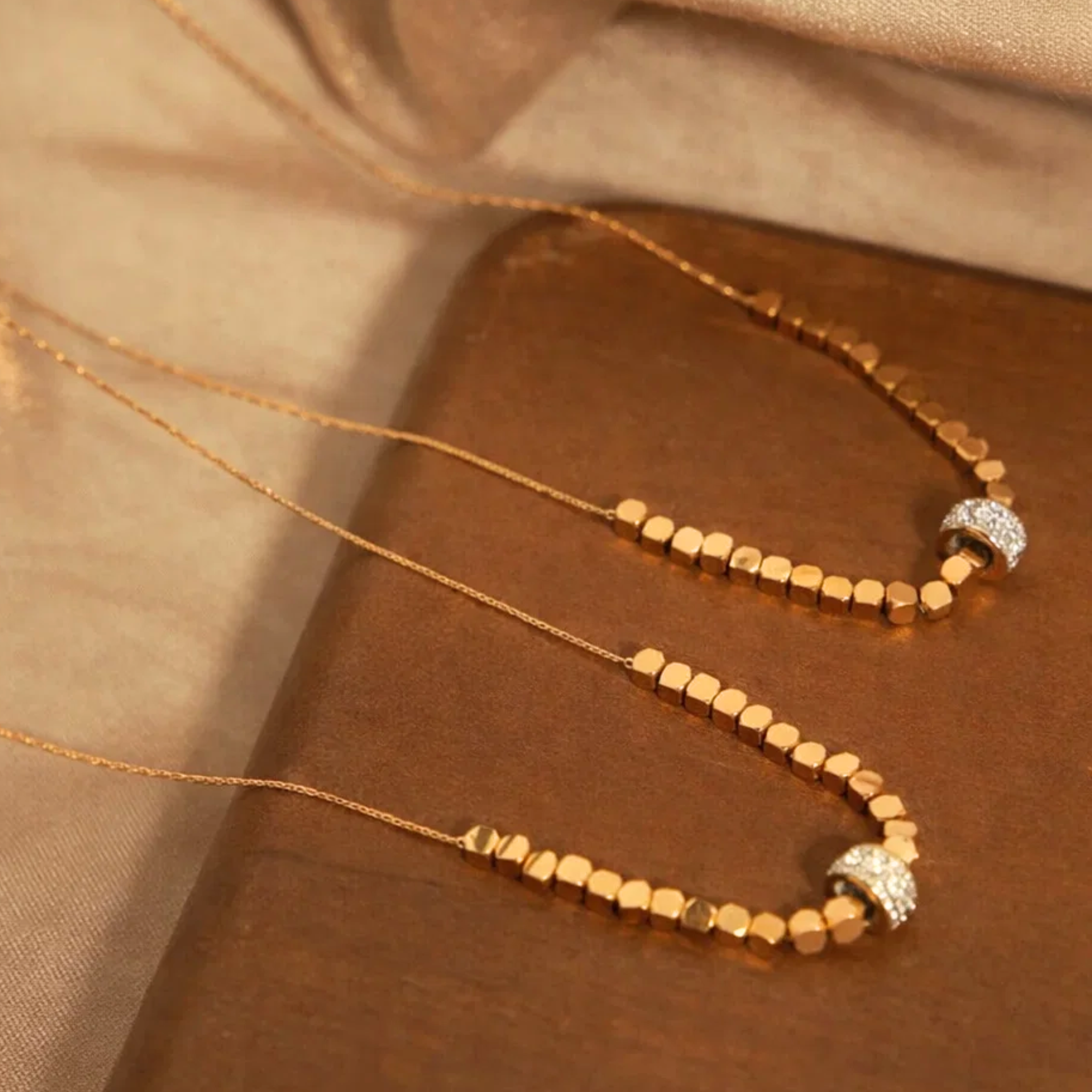 Two beaded necklaces on a wooden tray