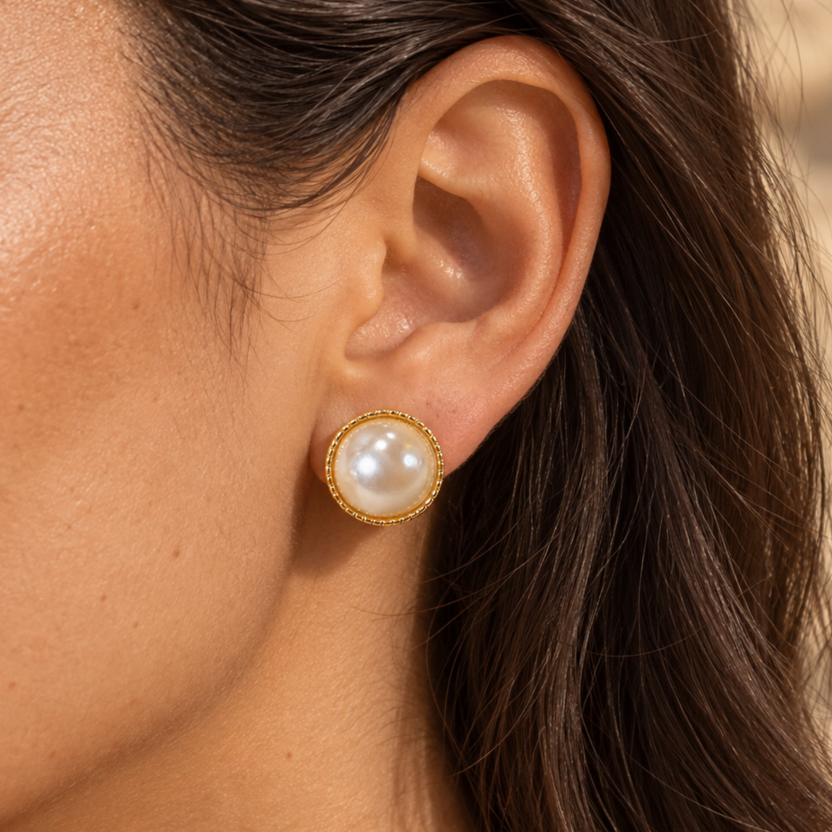 A woman wearing a pearl stud earring