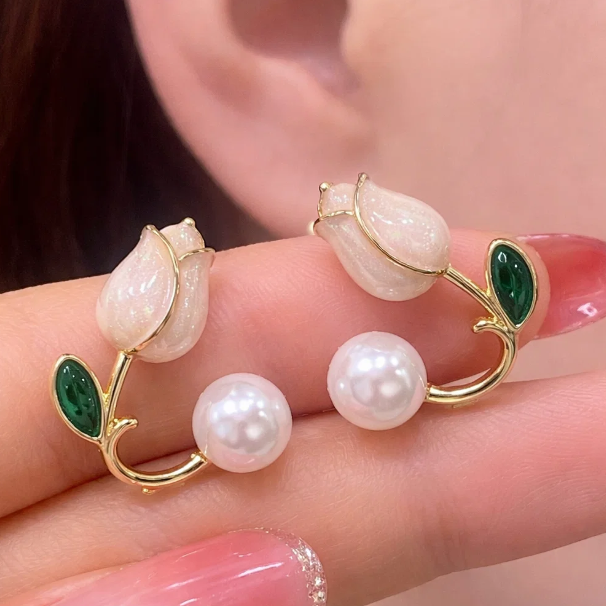 Pearl and white earring on a hand 