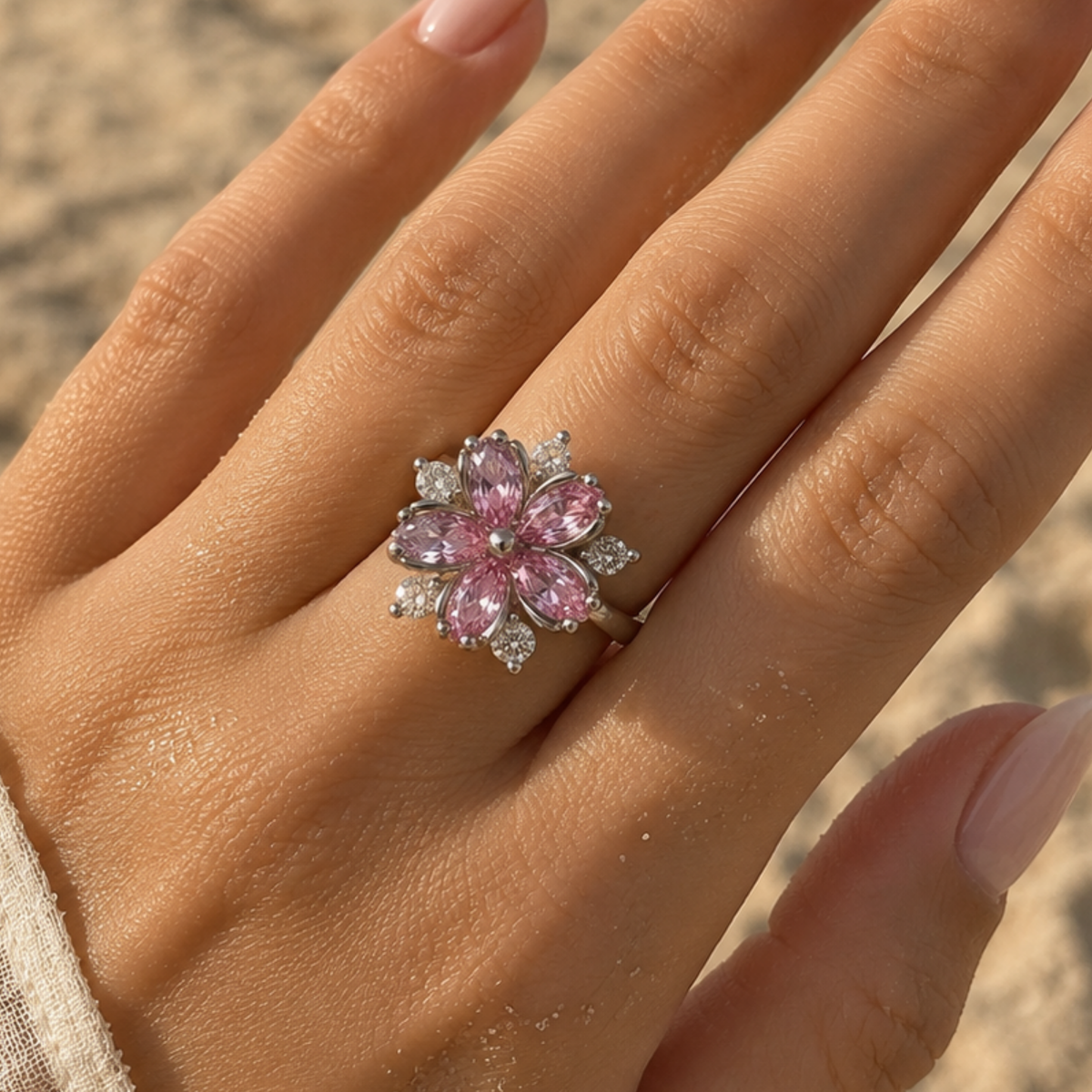 A silver flower-shaped ring with marquise-cut pink gemstones 